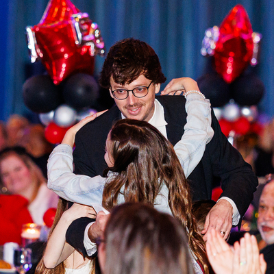 Dominic Bruno hugging a child at the awards ceremony