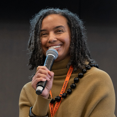 A speaker smiling at the CREA 8 Conference