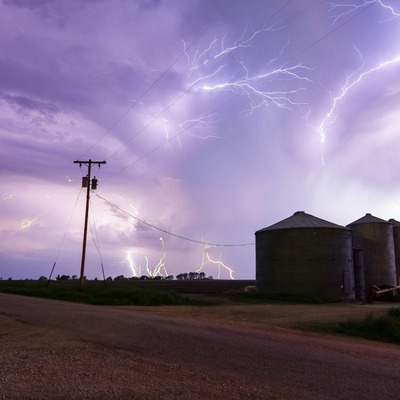 A storm with lots of lightning happening over a farm