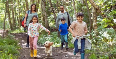 a family of five walks through the woods with their cute little dog. Sourced by BBC from Getty Images