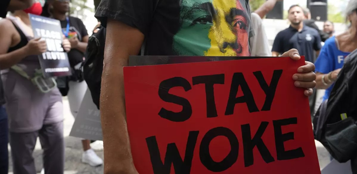 A person carries a sign during a march to protest Florida’s new standards for teaching Black history in August 2023 in Miami. (Lynne Sladky / Associated Press)