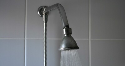 stock image of shower head spraying hot water. Courtesy of Pixnio