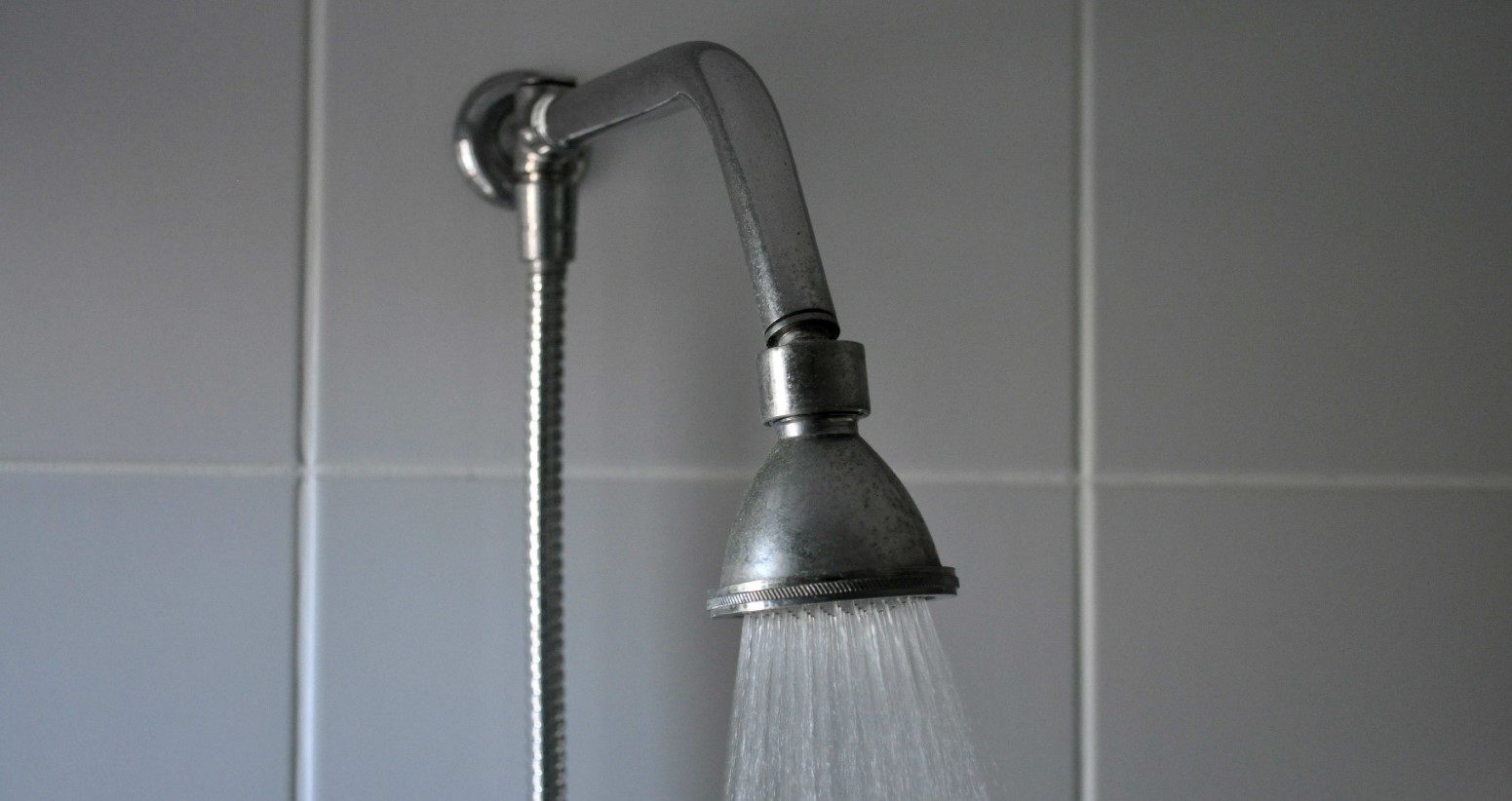 stock image of shower head spraying hot water. Courtesy of Pixnio