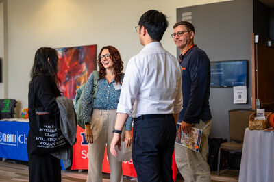 Photo depicts three individuals talking during the October 2025 Beyond Borders conference.