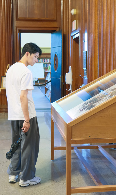 Mugyum Kim, a fourth-year undergraduate at CNU, looks at a display case during a tour of the University of Illinois Urbana-Champaign main library on July 13, 2026.