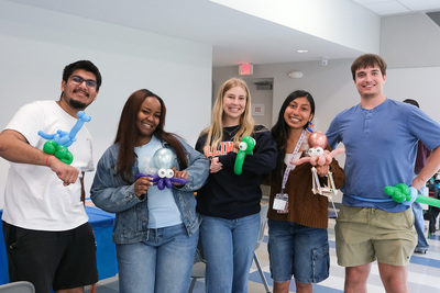 Student staff members from the Orchard Downs Community Center pose for a photo with their balloon animals and pirate sword during the April 24 International Families Celebration. The student staffers helped facilitate the event by setting up and taking down decorations, and connecting with the children through various activities.