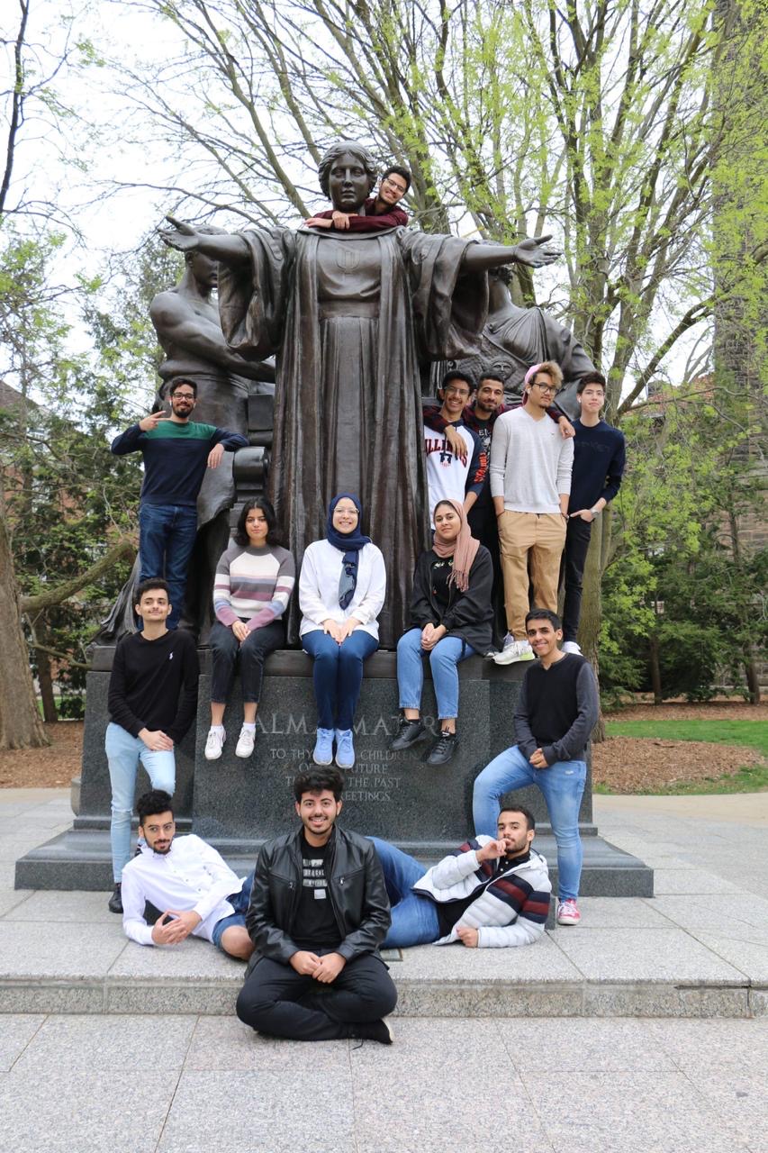 Doha Amer and other students pose on the Alma Mater statue