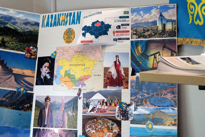 A poster board filled with pictures and facts about Kazakhstan is displayed on a table.