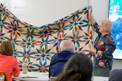Jennie Burden holds up a quilt she made for her daughter, Kathryn, during a Jan. 7 workshop inside the Siebel Center for Design. Jennie surprised Kathryn with the quilt for her wedding.
