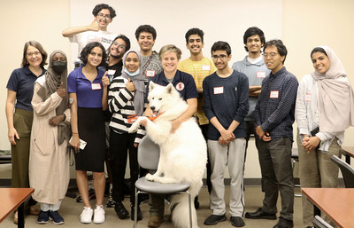 Group of faculty and students take a group photo with Kirby