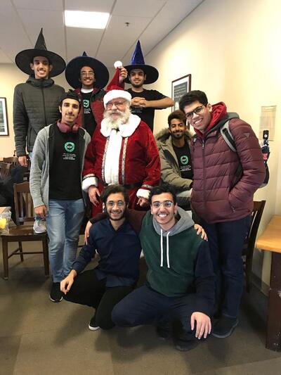 Rob Siedenburg is dressed up as Santa, posing with KGSP Foundation Year students in 2019.