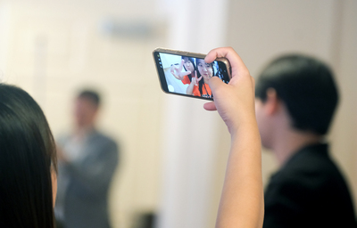 An Ajou University student from South Korea holds up a smartphone to take a selfie with another student during a closing ceremony at the University of Illinois Urbana-Champaign.