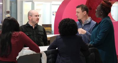 Grant Brewer (second from right in the far back), Associate Director for Strategic Initiatives, speaks with several fellows during a Fulbright Fellow welcome reception on Feb. 6 inside the Siebel Center for Design.