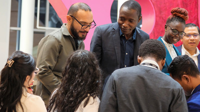 Fulbright Fellows Victor Romero, left, and Mahamat Doungous, right, look at photos they took with other fellows following a welcome reception on Feb. 6 inside the Siebel Center for Design.