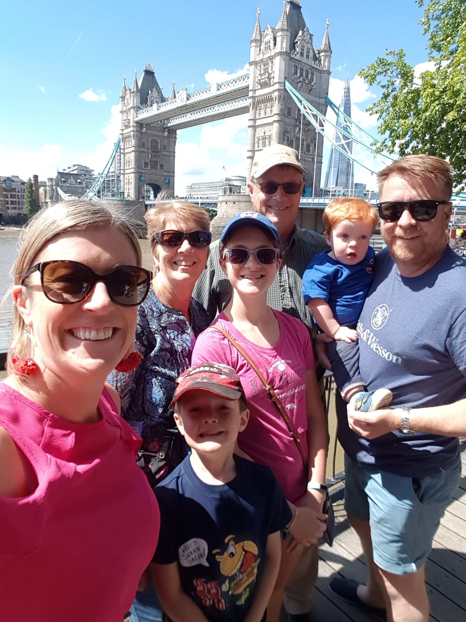 Melissa Blecher smiles with family members in front of Tower Bridge in London