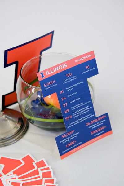The photo shows the centerpiece that was displayed on each table during the 2026 Sheth Distinguished Alumni Lecture on April 28 inside Illini Union Room 103. Each centerpiece featured a flower inside a fish bowl, and two block 'I' printouts that contained facts about the University of Illinois Urbana-Champaign.