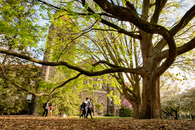 Trees framing a building and students walking on campus