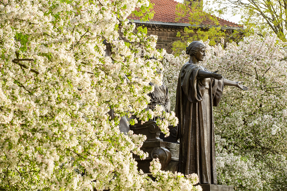 The Alma Mater statue surrounded by spring blossoms
