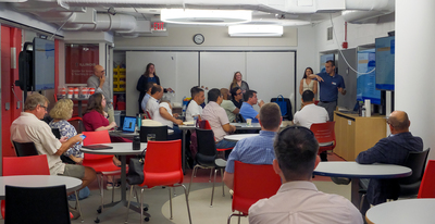 A wide shot view of inside Armory Room 182 during an orientation on July 20 for the week-long summer training program for faculty and staff from UAO. Throughout the week, CITL staff led sessions centered on how participants could deploy AI in their own classrooms realistically, teaching them essential skills they could use when designing, developing, and integrating AI teaching models, tools, and strategies.