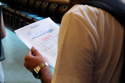 A graduate student holds a piece of paper that reads "The Welcome Quest" during the Graduate Connections Meet-Up on Aug. 18 inside the University YMCA.