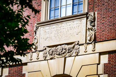 Tablet markers over the entrance of the Main Library, which is a historic library on the campus of the University of Illinois Urbana-Champaign. Built in 1924, the library was the third built for the school, replacing Altgeld Hall, which had become too small for the university's collections. Architect Charles A. Platt designed the Georgian Revival building, one of several on the campus which he designed in the style. The Main Library is part of the second largest university library collection in the United States. Photo taken at the University of Illinois Urbana-Champaign on Wednesday, June  25, 2025.  (Photo by Fred Zwicky / University of Illinois Urbana-Champaign)