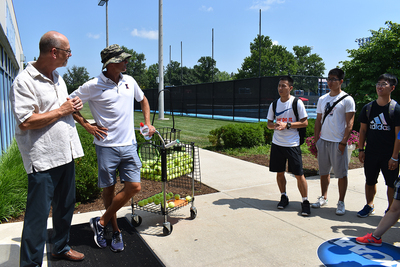 Don Hardin talking to students at an outdoor tennis court