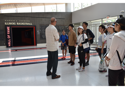 Don Hardin is talking to students in front of Mannie L. Jackson Illinois Basketball Hall of Fame