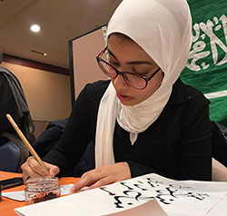 KAUST student writing at a table