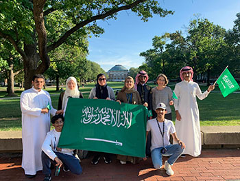 KAUST Gifted Student Program participants stand on the Quad behind the Illini Union, holding a Saudi Arabian flag