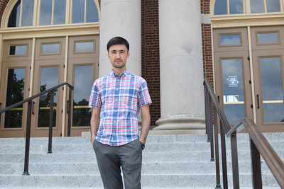 Sardor Musaev poses in front of Foellinger Hall