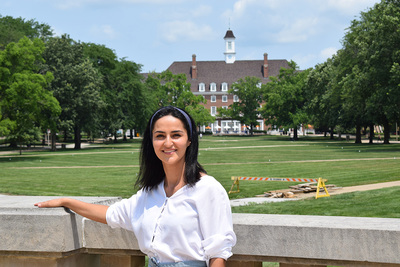 Furough Shakarmamadova poses in front of Foellinger Hall