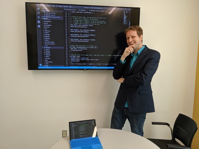 Wade Fagen-Ulmschneider poses in front smart board in a classroom