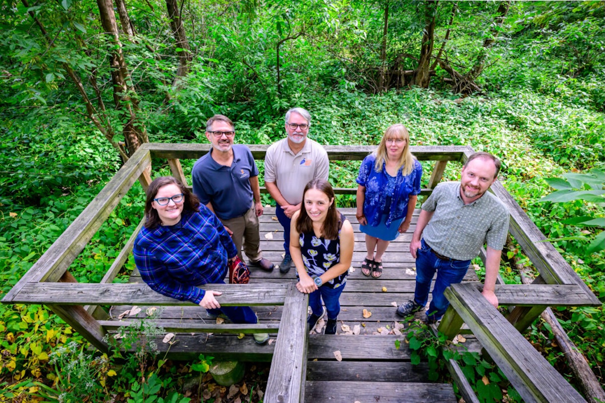 Research team stands on a observation deck in Busey Woods.