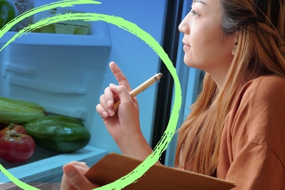 A woman notes what is in her refrigerator.