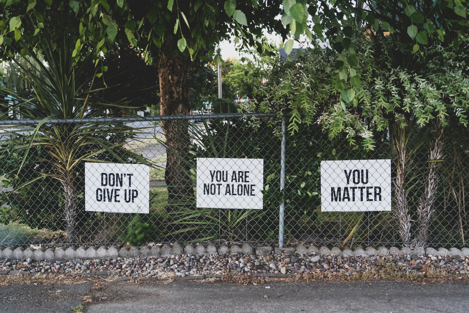 Don't give up, You are not alone, You matter signage on metal fence