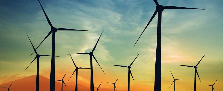 Wind turbines against sunset.