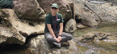 Jenna Shelton sits by a river during a field research trip.