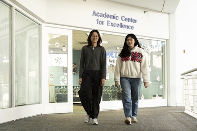 Zoey and Aislinn walking by the Academic Center for Excellence office at the University of Illinois Chicago.