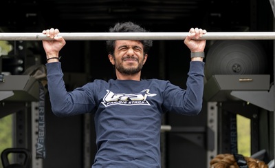 A University of Illinois student cringes as they do a pull-up