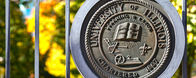 The seal of the University of Illinois Board of Trustees on a metal gate