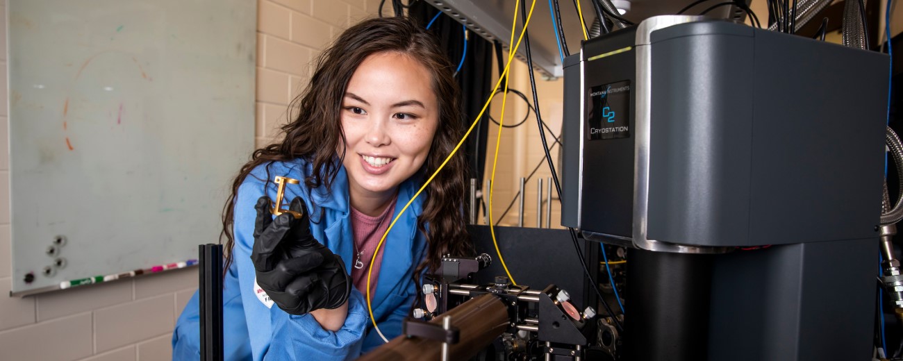 a woman examining wires and equipment in a laboratory