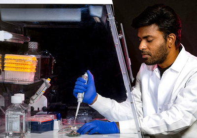 UIC Postdoctoral Associate Gunipe Prasanth holding a syringe in a laboratory setting. (Photo: UIC College of Engineering)