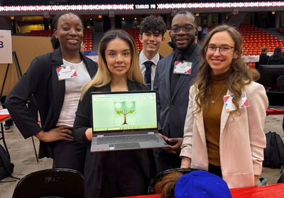 UIC students posing with an open laptop at the Engineering Expo 2026 (Photo: Carlos Sadovi/UIC)