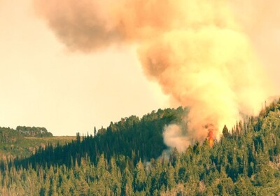 smoke rising from a wildfire on a mountainside