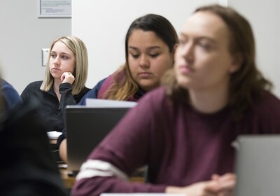 Students in a legal studies class at UIS listen to a lecture and take notes on their laptops