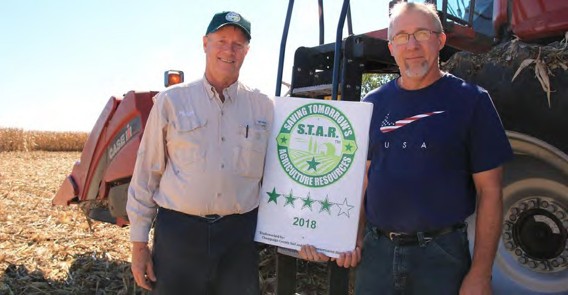 Two farmers holding STAR sign