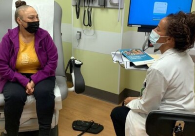 a doctor sitting with a patient in a hospital room