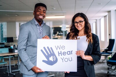 two people holding a sign that says "We Hear You"
