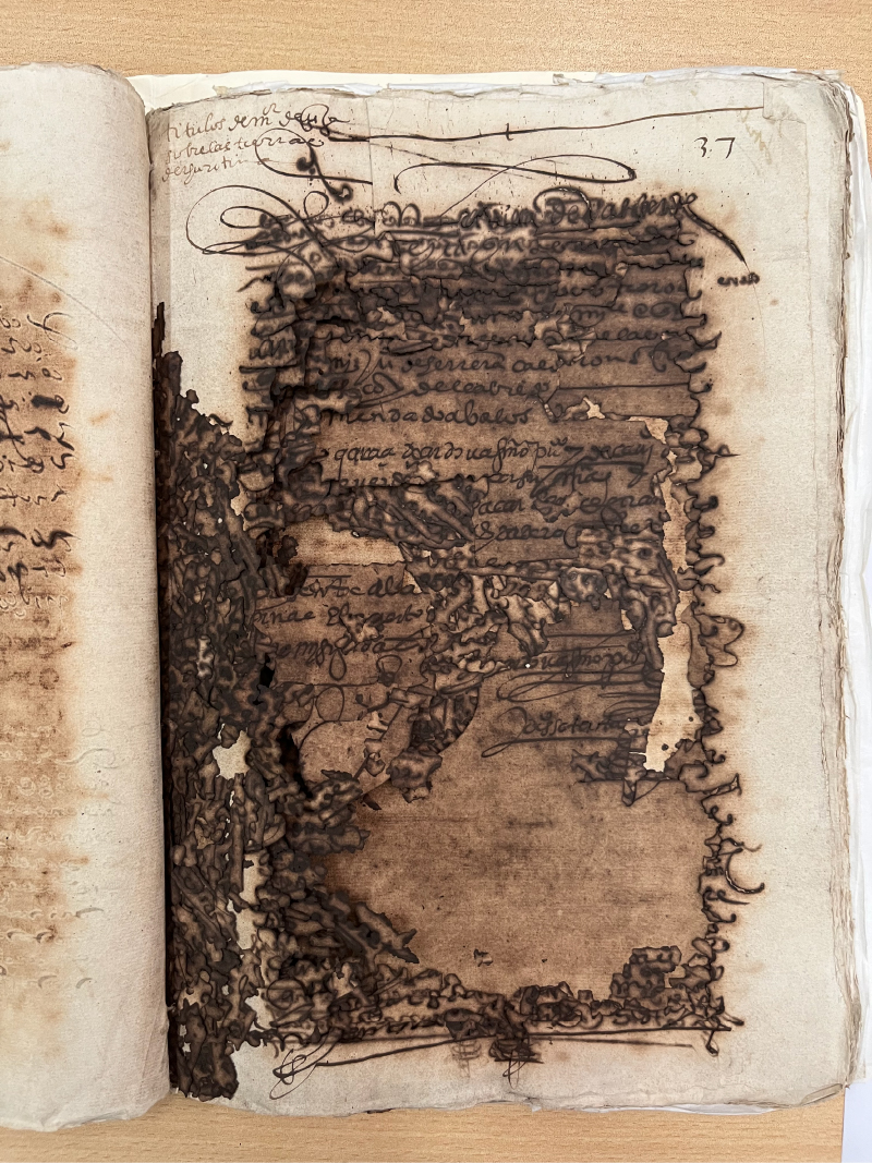 The Andean Archive. Manuscript showing a heavily damaged page with partially legible handwritten text in brown ink.